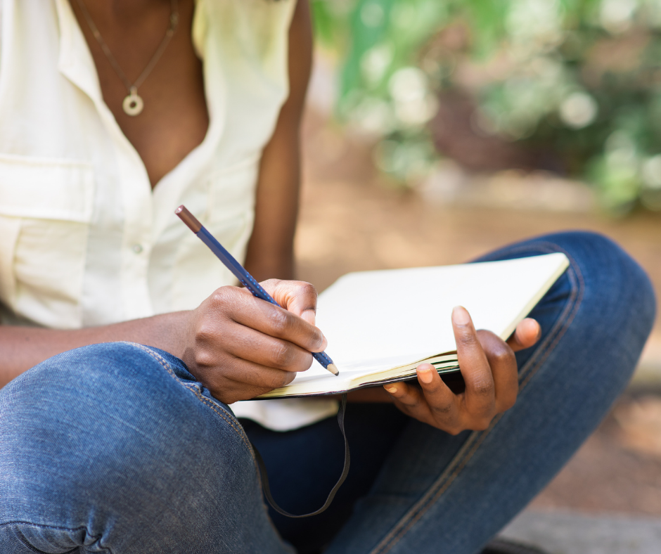 woman sitting outside taking notes